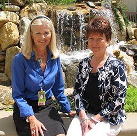 2 ladies in front of a waterfall